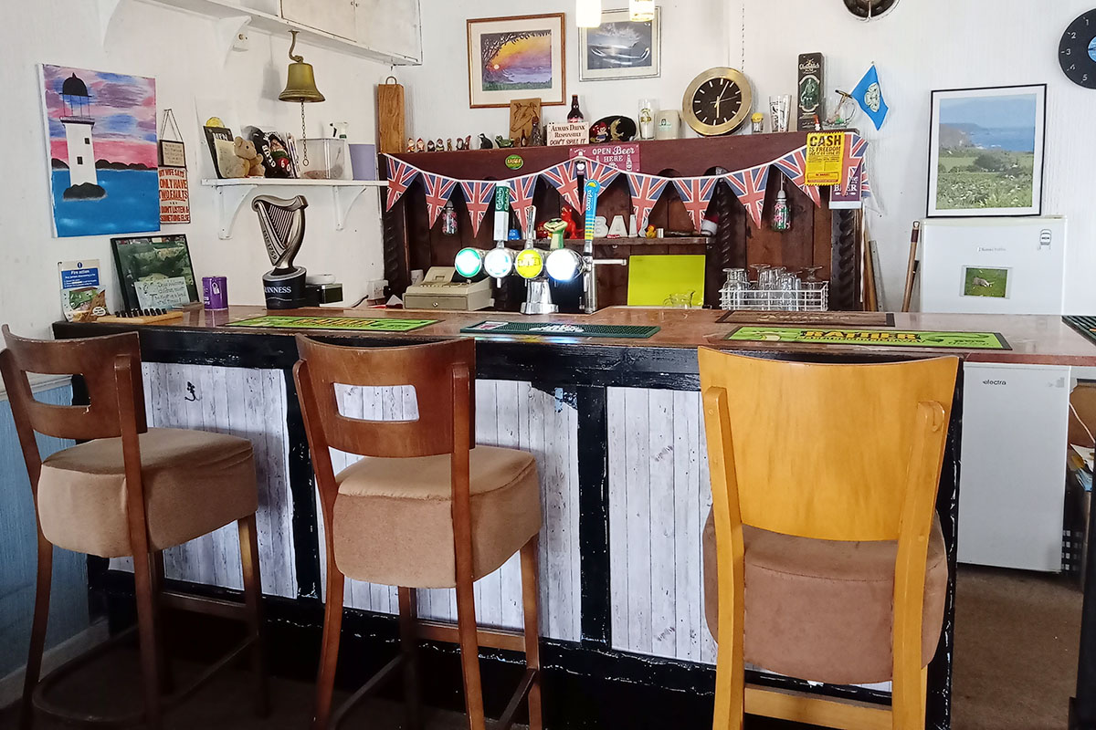 The bar at Seaview Holiday Park, with bar stools and Union Jack bunting above the taps